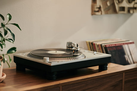 MC Cadenza cartridge displayed on a turntable with vinyl records in the background