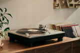 MC Cadenza cartridge displayed on a turntable with vinyl records in the background